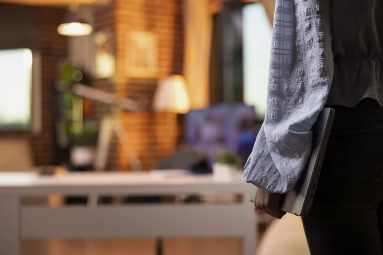 Entrepreneur walking into apartment with laptop sunset copy